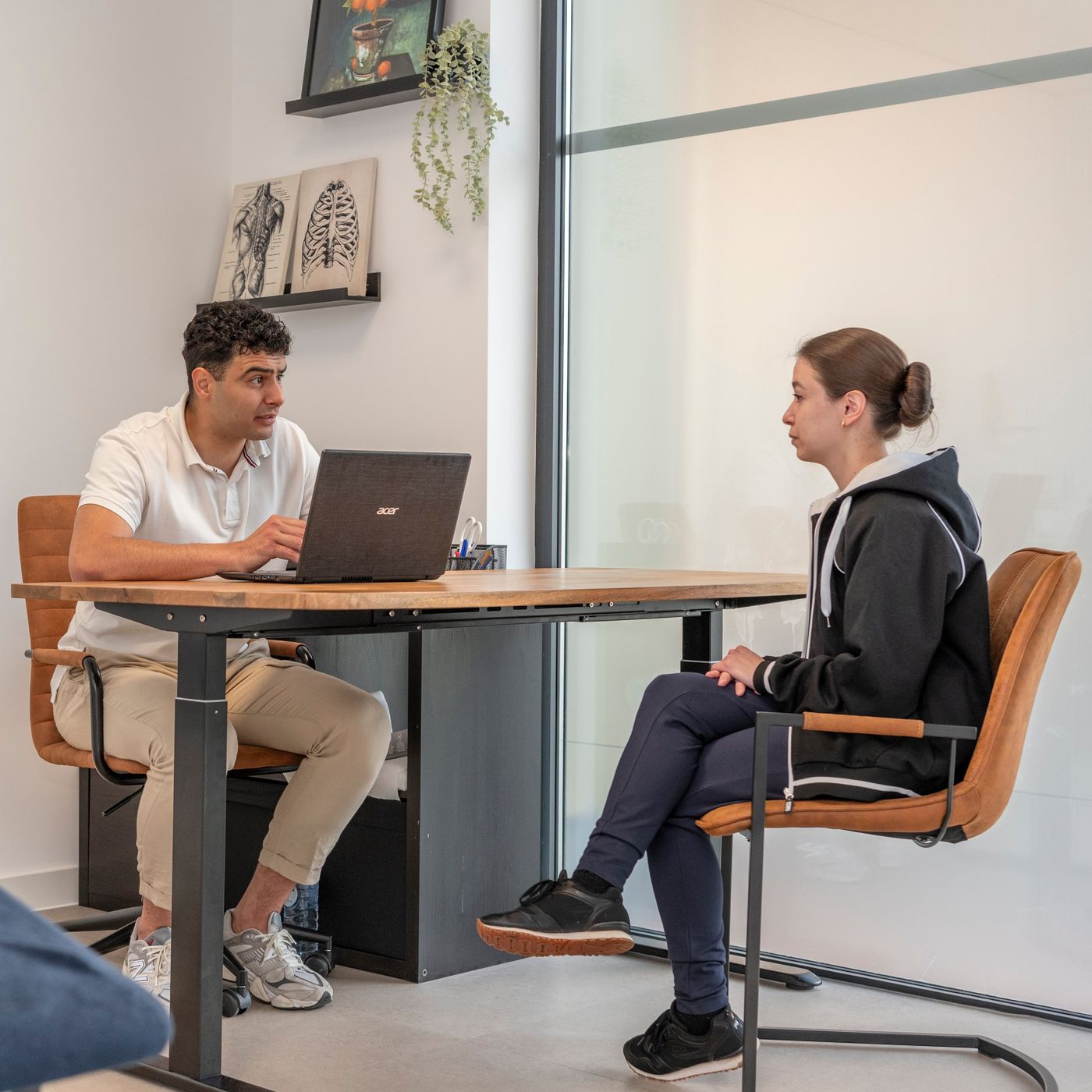 Een fysiotherapeut van Lenta in gesprek met een patiënt